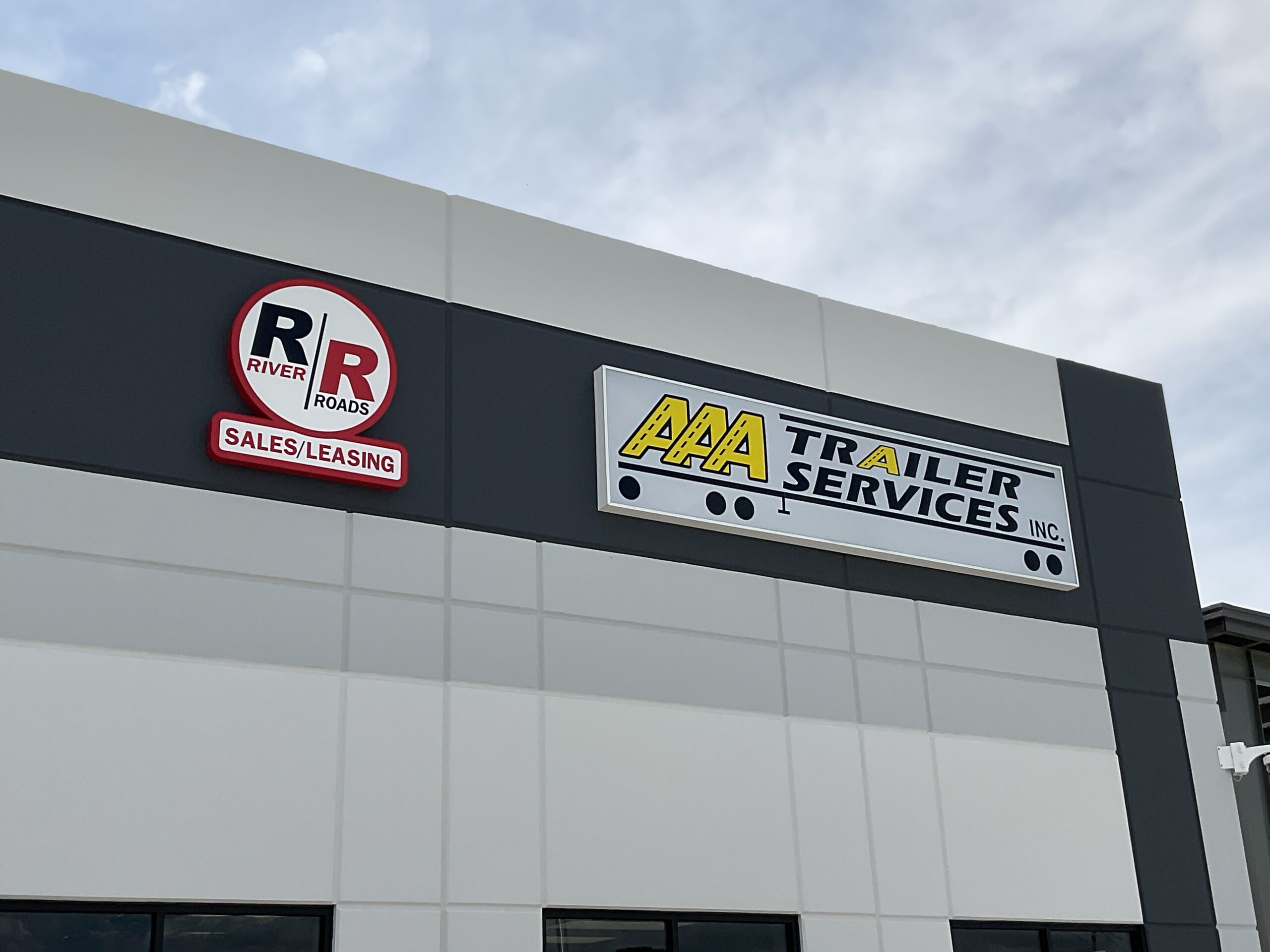 Building signage -2 River-Roads Sales and Leasing building signage with AAA Trailer Services